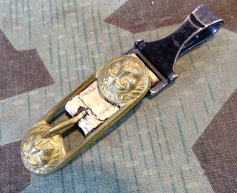 Buntmetall Löwenkopf Schließe auf weißem Lackleder, für Blankwaffen Gehänge um 1916, 1. Weltkrieg Buntmetall Löwenkopf Schließe auf weißem Lackleder, für Blankwaffen Gehänge um 1916, 1. Weltkrieg