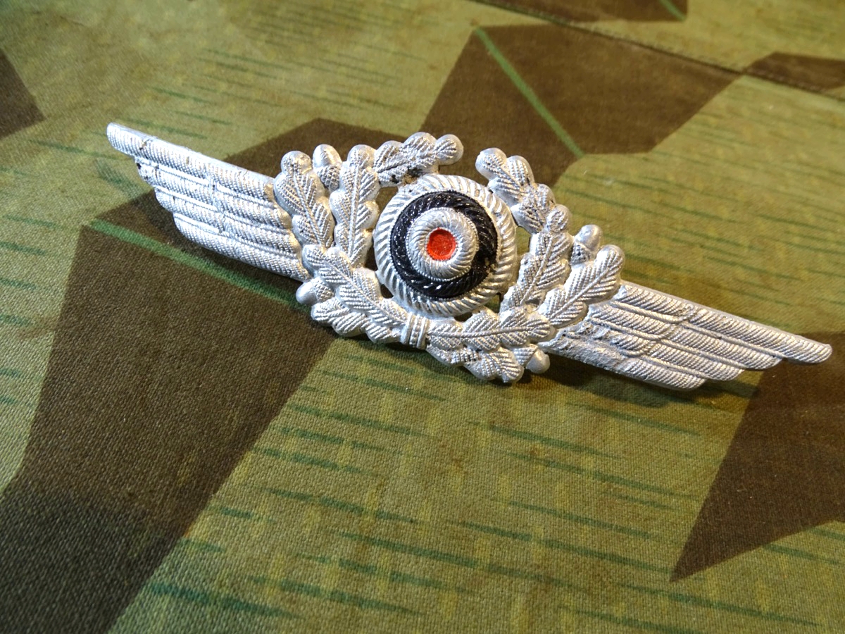 Schwinge mit Eichenlaub und Kokarde für Luftwaffen Schirmmütze, Alu, Splinte erhalten. 