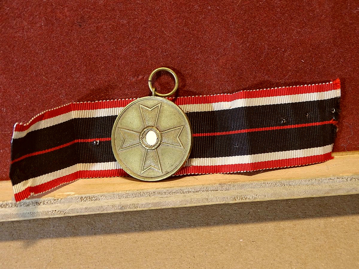 Kriegsverdienstmedaille, Buntmetall mit  Bandabschnitt.