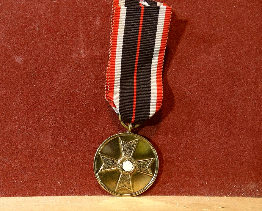 Kriegsverdienstmedaille, Buntmetall mit Bandabschnitt.