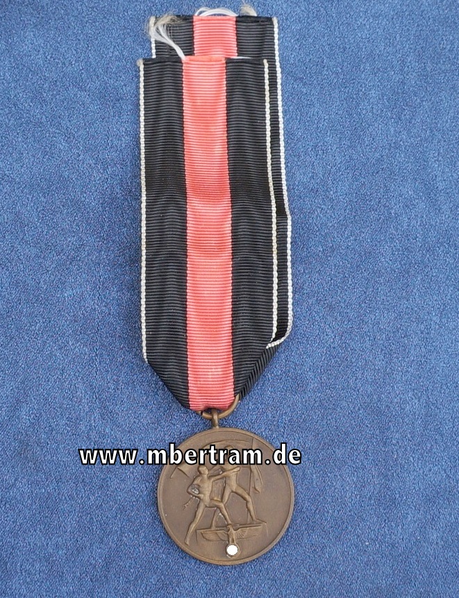 Eine Erinnerungsmedaille zum 1. Oktober 1938 am Band.