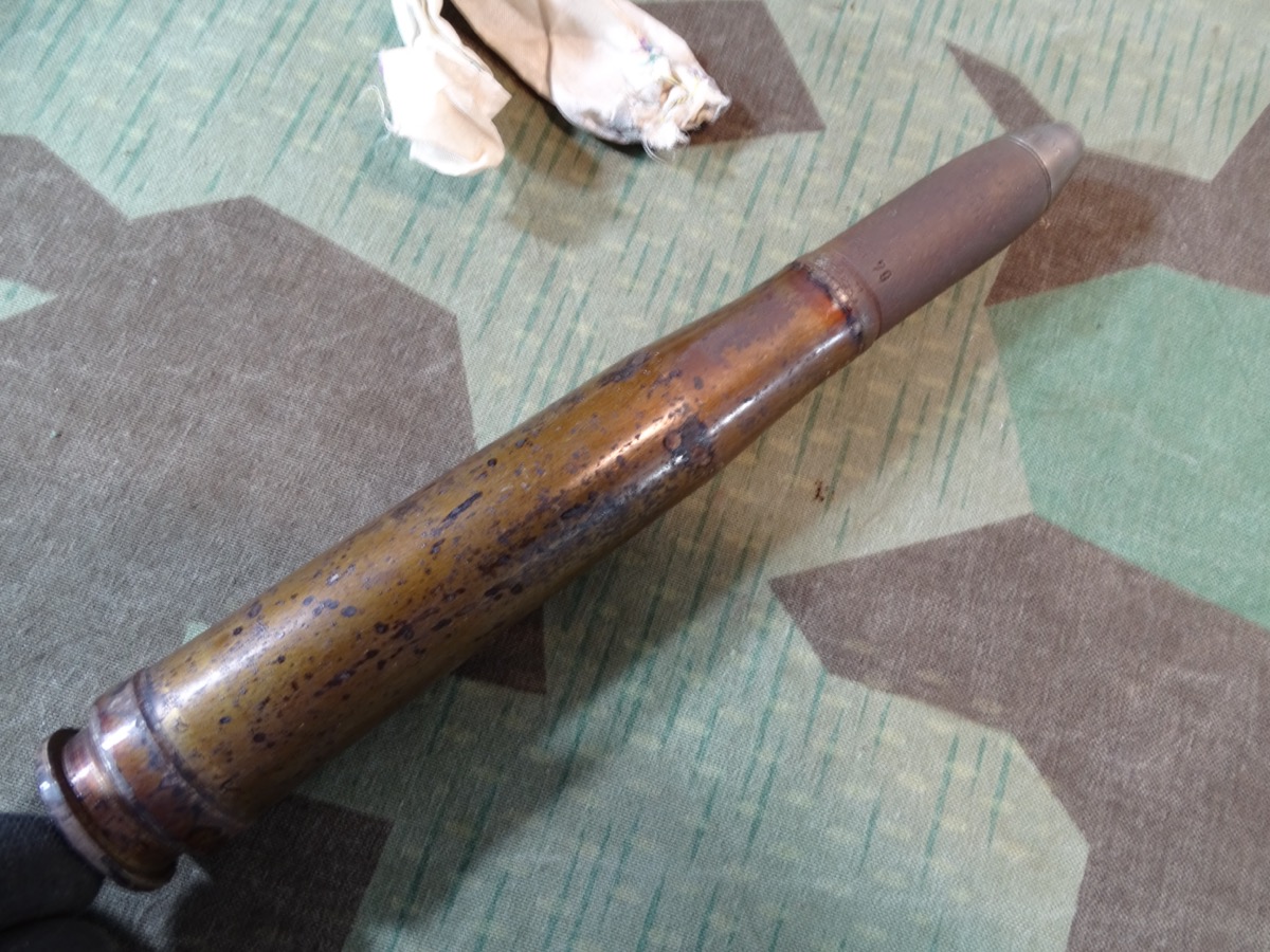 Deko-Patrone 2 cm Flak 38, lackierte Stahlhülse, Eisenzünder, Ladungssäckchen