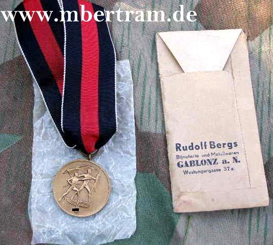 1. Okt.r 38 Medaille mit Tüte: " Rudolf Bergs, Gablonz"