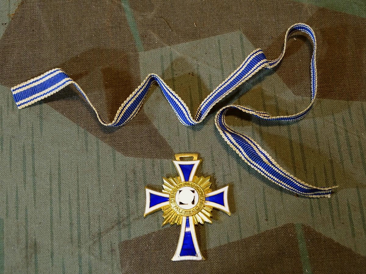 Mutterkreuz / Ehrenkreuz der Deutschen Mutter in Gold mit Bandabschnitt. Mutterkreuz I.Stufe. Emaillechip