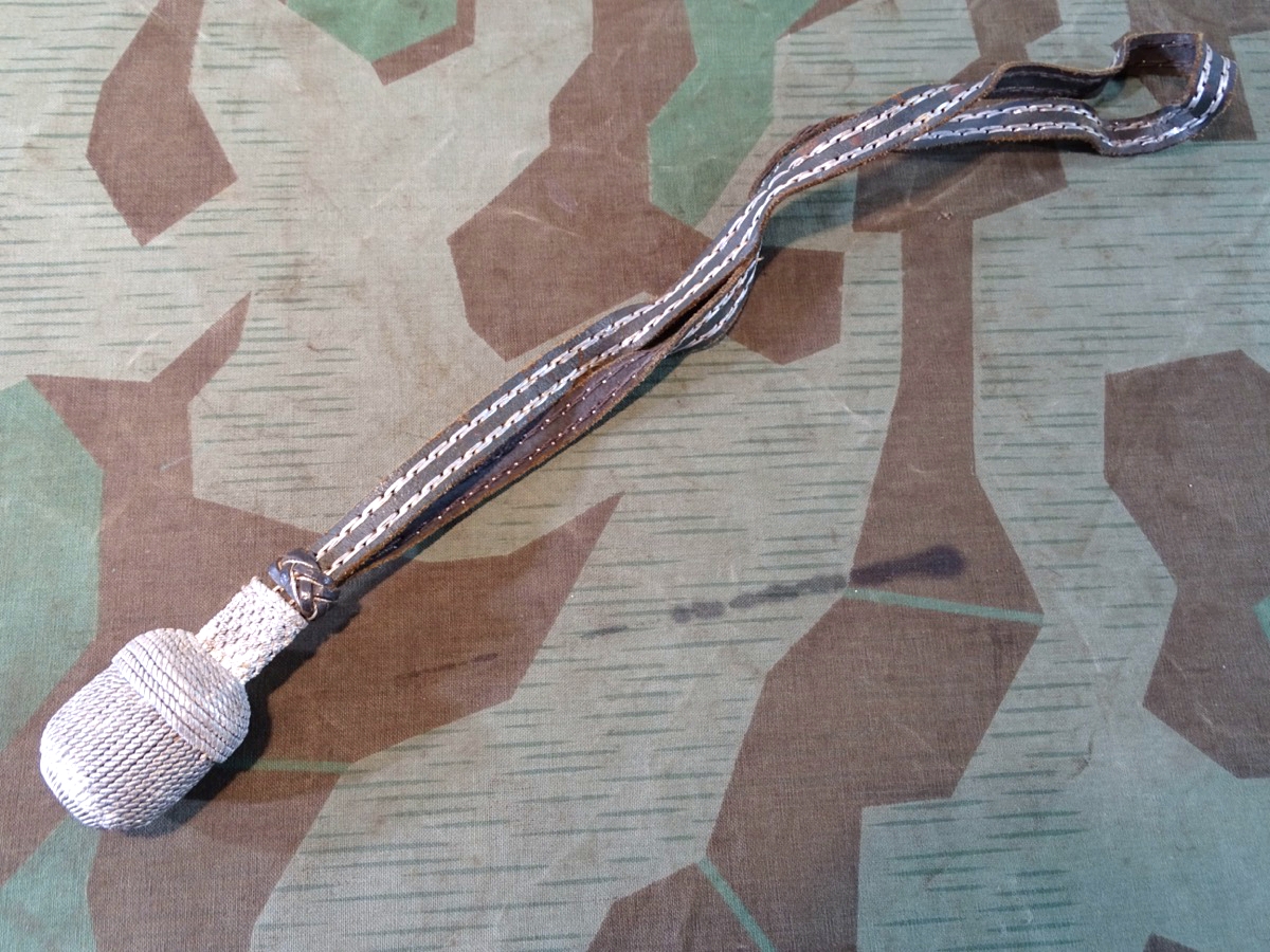Portepee für Offizierssäbel Wehrmacht, graues Lederband mit Metallfaden Durchzügen.  Portepee für Offizierssäbel Wehrmacht, graues Lederband mit Metallfaden Durchzügen.
